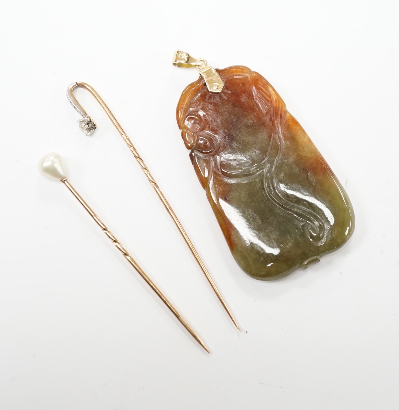 A yellow metal and diamond cluster set stick pin, 69mm, a yellow metal and cultured pearl set stick pin and a 14k mounted jade pendant.